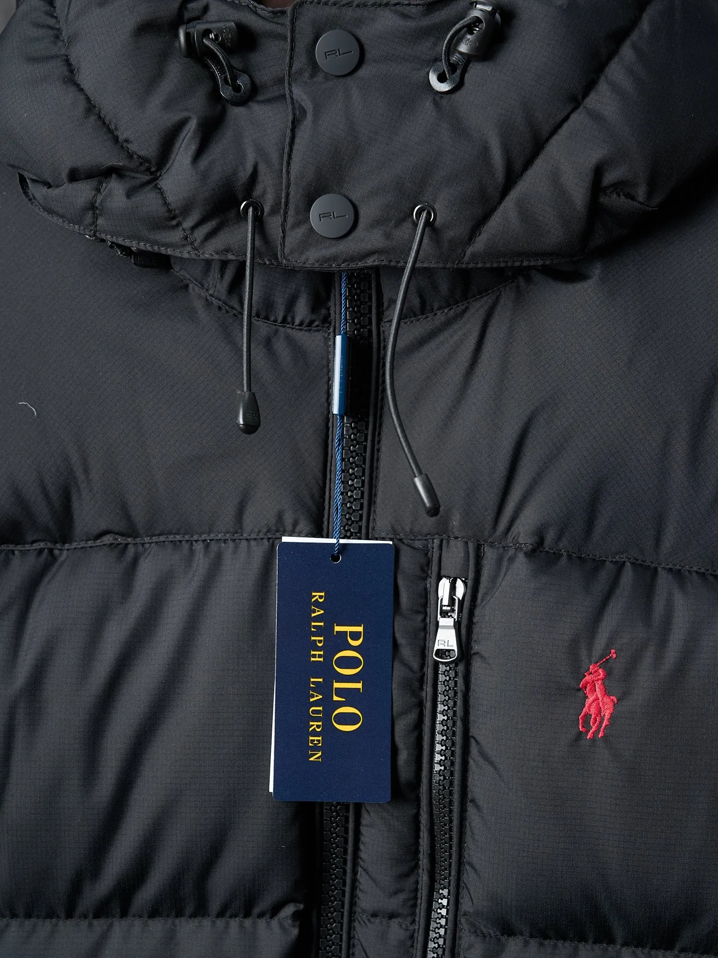 P940 Actual auction】Ralph Lauren/Ralph Lauren classic red label pony embroidered zipper hooded down jacket [Ready stock] S M L XL is made of 90 white duck down with a weight of 260g, ensuring excellent thermal insulation performance. After strict screening and processing, the velvet is not easy to drill, ensuring durability. The nylon fabric has good windproof and waterproof properties, which can effectively block the intrusion of wind and rain from the outside. It keeps the interior dry and is suitable for wearing in humid or rainy environments.  The red label on the chest is made with an imported MECLO embroidery machine. The original pattern is scanned first, and then high-quality silk thread is used to make a pattern. The density effect is adjusted by continuous pattern making.  Detachable hood: The down jacket is equipped with a detachable nylon hood, which users can easily remove or install according to weather changes or personal preferences, which is both practical and convenient.  Exquisite details: the zipper design is simple and elegant, easy to operate; the closing design of the cuffs and hem effectively prevents the intrusion of cold wind, improving the warmth and comfort of wearing.  All the hangtags, wash marks, air holes, and four-button buttons are all custom-made using original one-to-one molds.